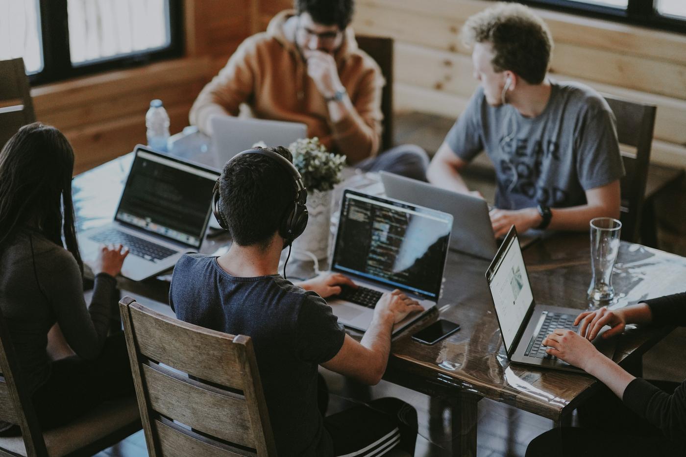 Equipe trabalhando em notebooks numa mesa de escritório